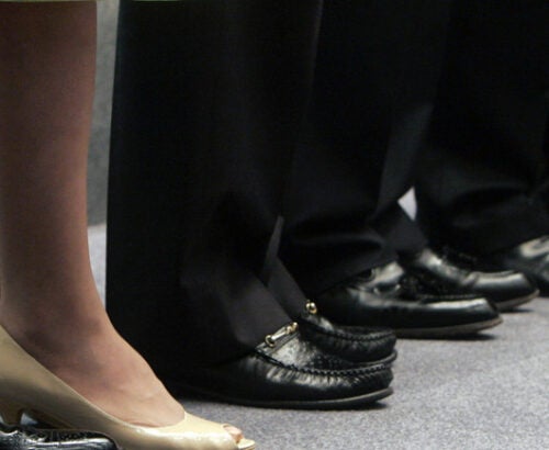 One pair of women's work shoes amid many men's shoes
