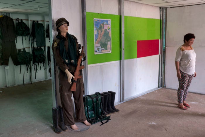 Picture of mannequin in army attire and woman standing nearby