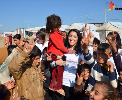 Yezidi woman holding a young girl and surrounded by group of children