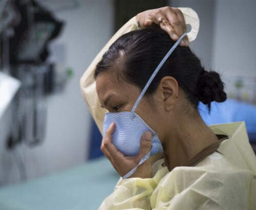 woman putting on a face mask