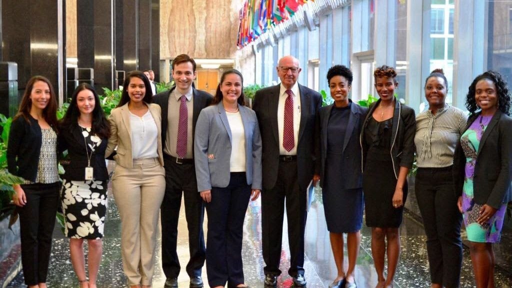 A group of State Department employees smile at the camera