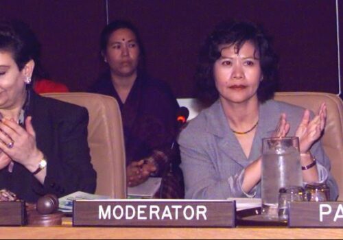 An image of four women sitting on a panel for speakers at a formal negotiation.