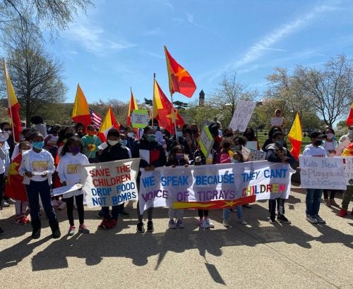 An image of a group of people marching in Washington DC. illustrates the topic of the post on this webpage. The image shows Tigrayan kids holding a protest amplifying the atrocities happening to kids in Tigray, as well as their grandparents, cousins, and more widely, the people of Tigray.
