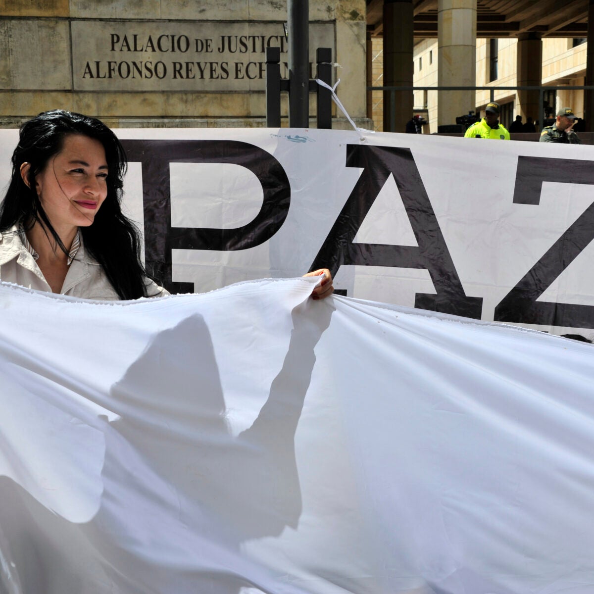 A woman holds a white flag during a demonstration to demand the immediate endorsement of the new peace agreement between the Colombian government and the FARC guerrilla outside the Colombia's Constitutional Court in Bogota, on December 12, 2016.